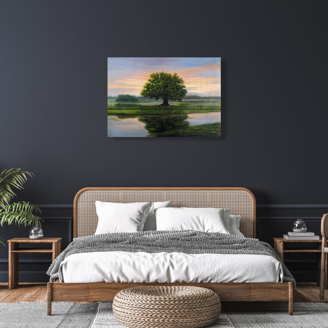 Oil painting features a single tree with green and yellow leaves, standing proudly on the bank of a calm river